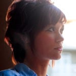 Profile of a woman looking thoughtfully to the side.