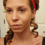 A woman with curled hair and a red headband.