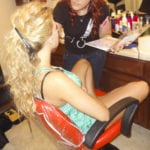A woman with long blonde hair sitting in a salon chair.