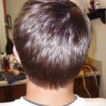 Back view of a person's head with short brown hair.