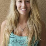 A smiling young woman with long blonde hair wearing a turquoise top.