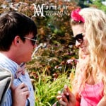 A man and woman smiling outdoors in sunny weather.