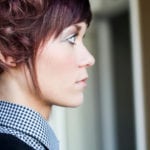 Profile of a woman with short hair and makeup.