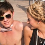 A young man and woman enjoying a sunny day, smiling and interacting.