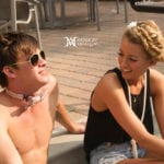 Two people enjoying a sunny day outdoors, one shirtless and wearing sunglasses.