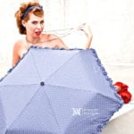 A woman with red hair holding a purple umbrella.