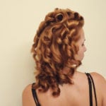 Woman with curly, styled hair viewed from the back.