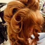 Close-up of vibrant red hair styled in voluminous curls.