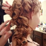 A woman with long, curly hair styled in ringlets.
