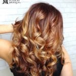 Woman with long, curly, highlighted hair.