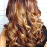 Long, curly hair with blonde highlights.
