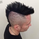 A man with a styled mohawk and shaved sides featuring a lightning bolt design.