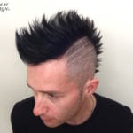 Man with a tall black mohawk and shaved sides.