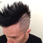 Man with a spiked mohawk and shaved sides with design.