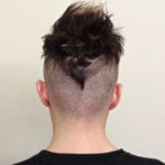 A creative hairstyle shaped like a bird on the back of a man's head.