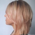 Side view of a woman with blonde layered hair.