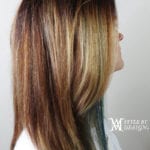 Side profile of a woman with layered brown and blonde hair.