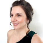Portrait of a woman with dark hair in an elegant green dress.