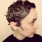 Profile of a person with styled short hair and hairpins.
