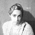 Black and white portrait of a woman with vintage hairstyle and pearls.