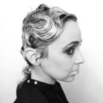 Black and white profile portrait of a person with styled short hair.