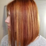 A woman with straight, shoulder-length red hair.