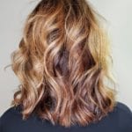 Back view of shoulder-length wavy hair with blonde and brown highlights.