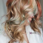 A close-up of wavy blonde hair with highlights.