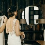 Bride in a white lace dress preparing for her wedding.