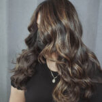 A woman with long, wavy hair covering her face.