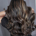 Long wavy hair with blonde highlights.