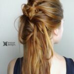 Intricate braided hairstyle on blonde hair.