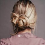Elegant low bun hairstyle on blonde hair from the back.