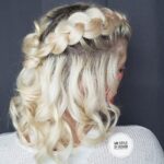 Blonde hair styled in loose curls with a braided crown.