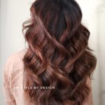 Long wavy brown hair with subtle highlights.