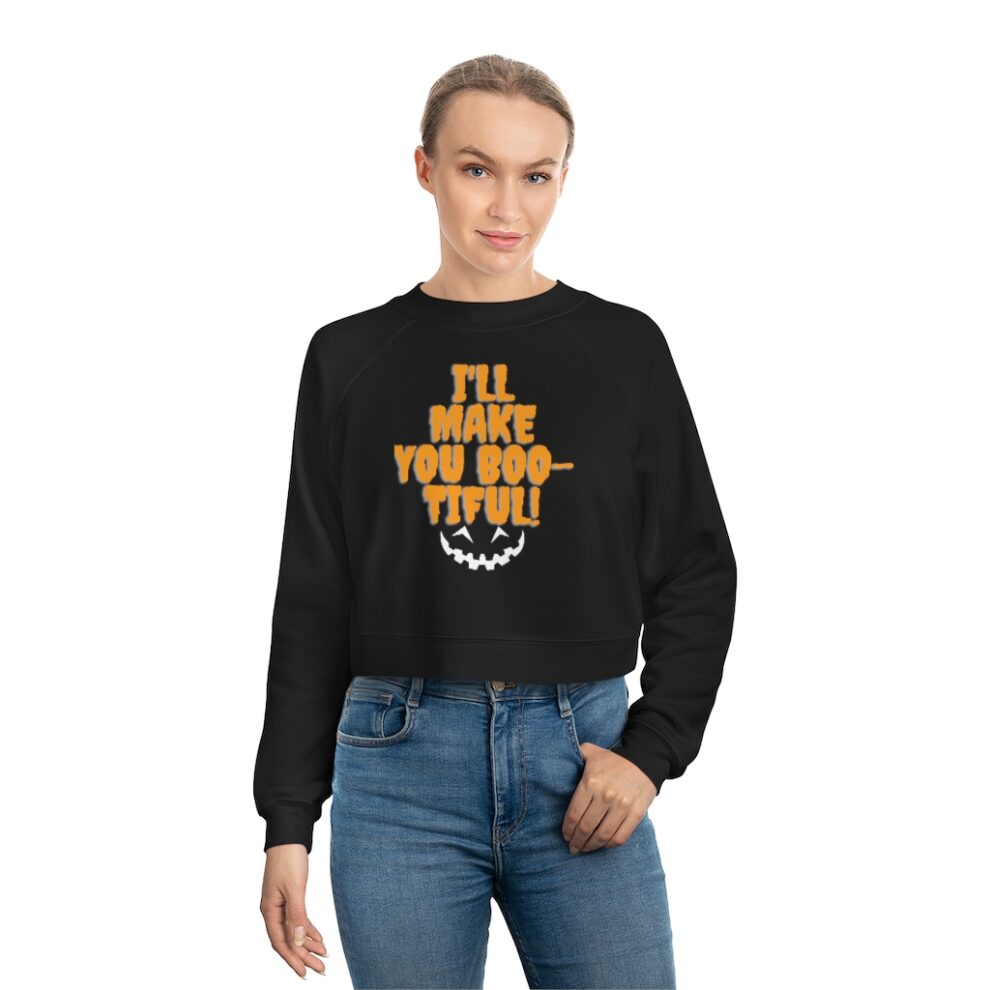 A woman wearing a black sweatshirt with orange text and a graphic design on the front, paired with blue jeans.