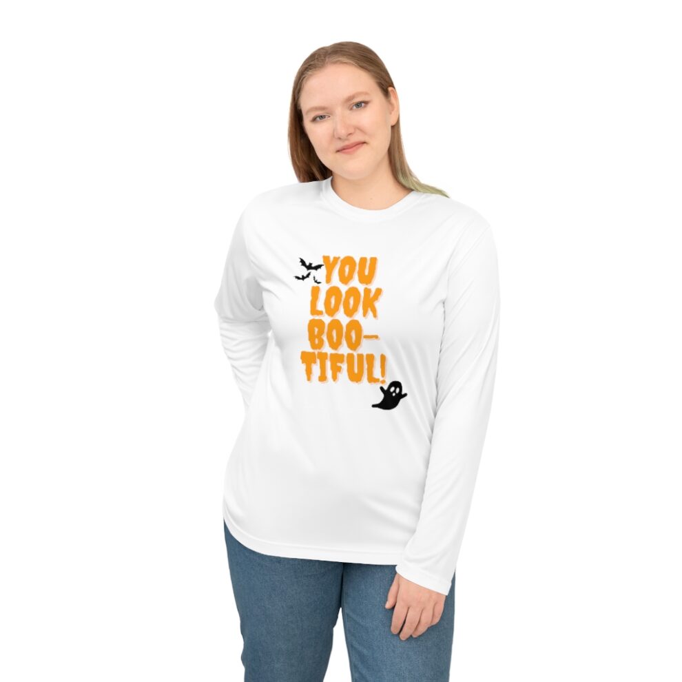 A woman wearing a white long sleeve shirt with an orange and black design.