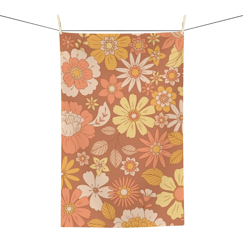A hanging towel with an orange and yellow floral pattern.