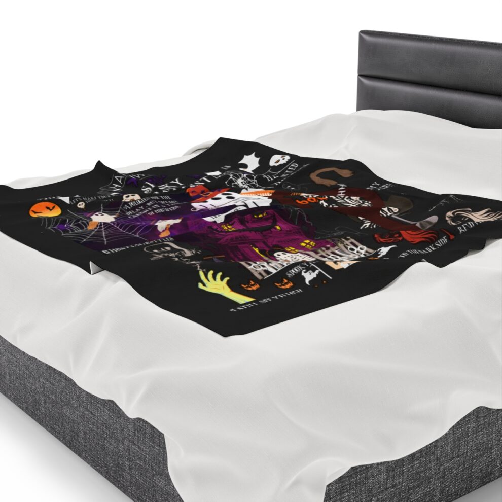 A bed with a black and white blanket on top of it