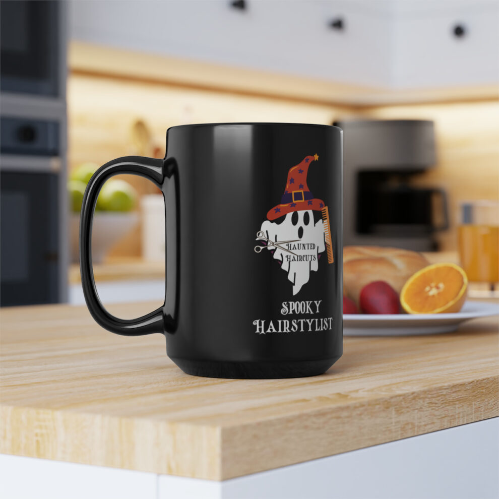A black coffee mug sitting on top of a wooden counter.
