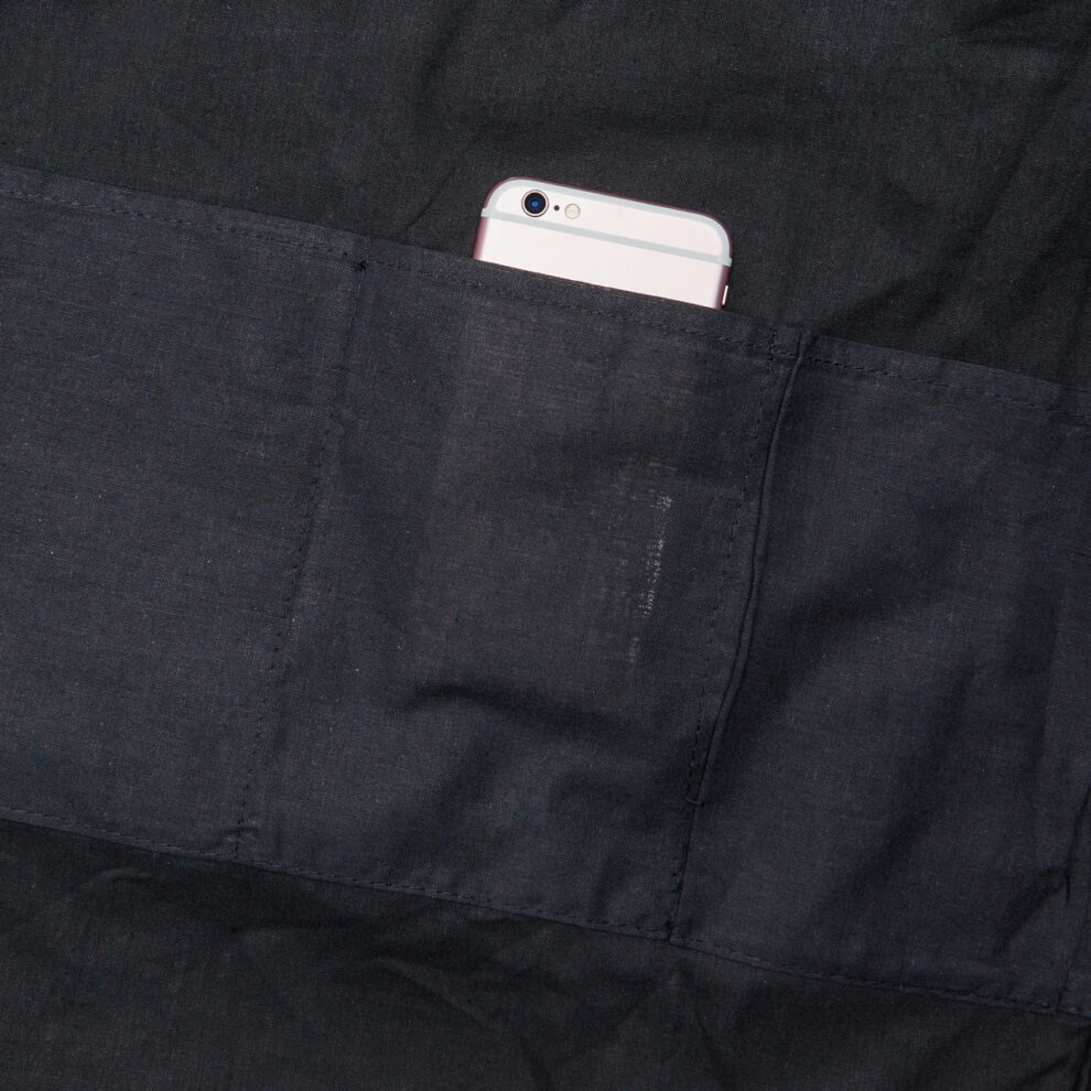 A cell phone is in the pocket of a black jacket.