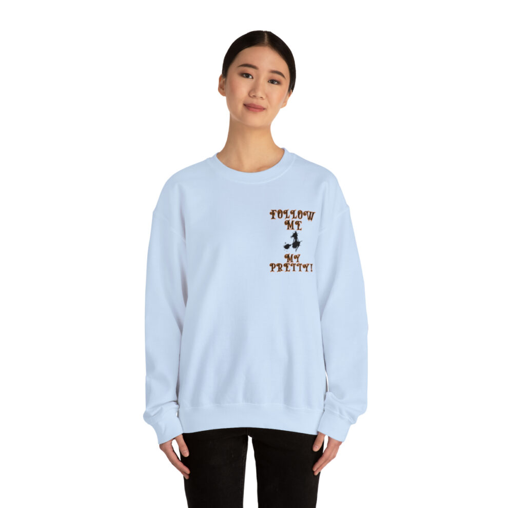 A woman wearing a light blue sweatshirt with a brown and white design on the front.