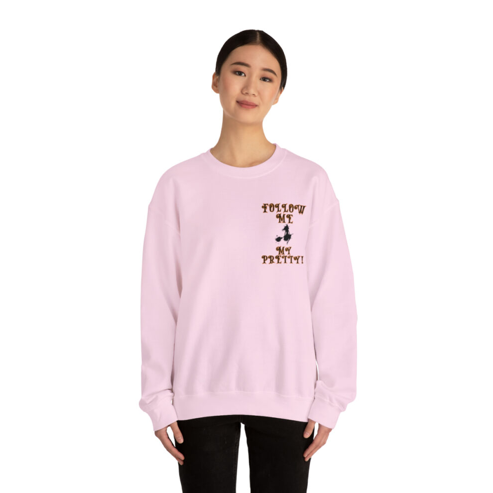 A woman wearing a pink sweatshirt with a picture of a person.
