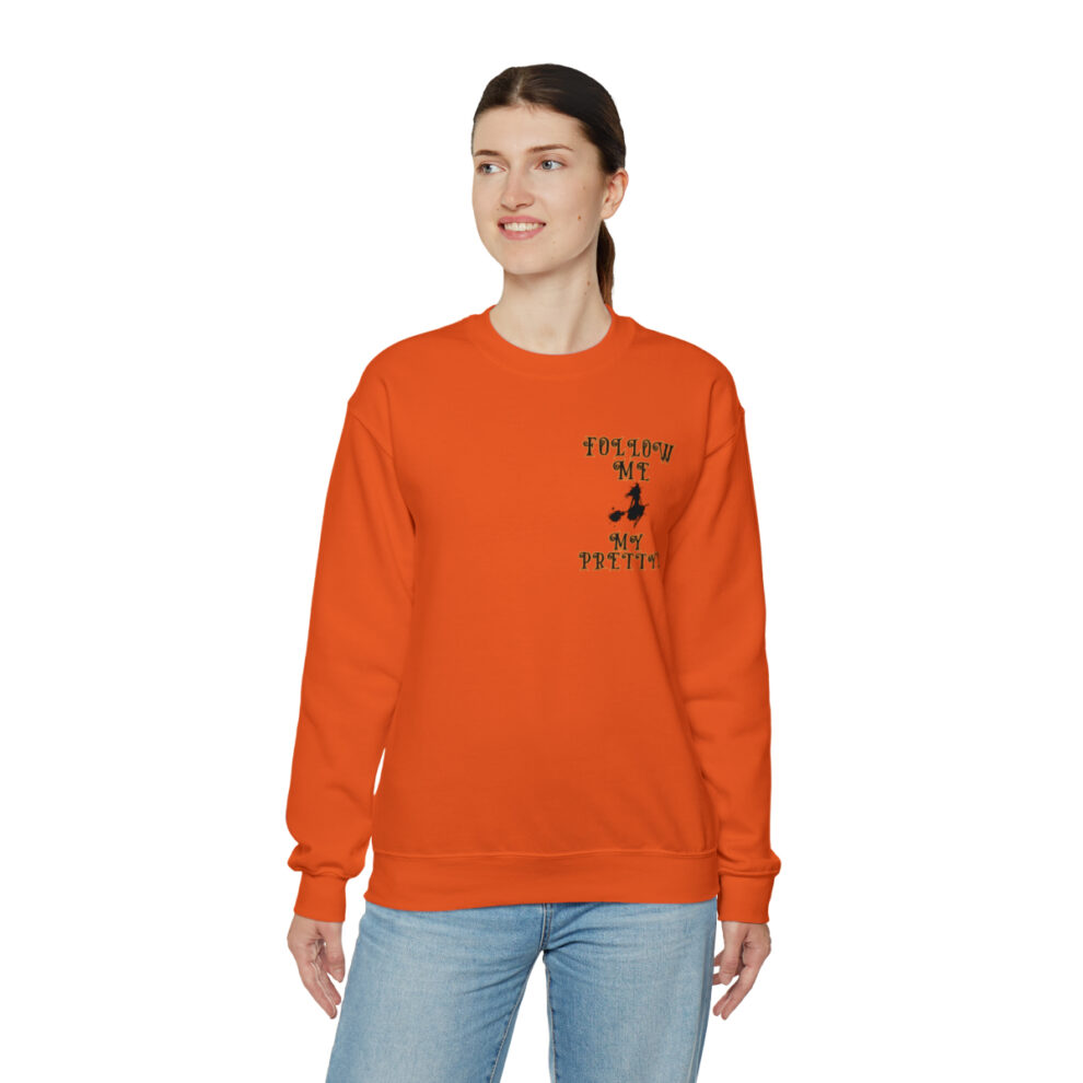 A woman wearing an orange sweatshirt with the words " freedom to be happy ".