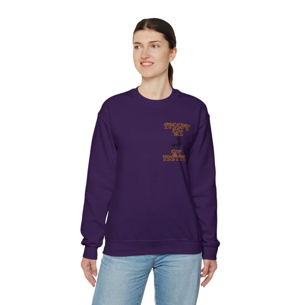 A woman wearing a purple sweatshirt with an image of a person on it.