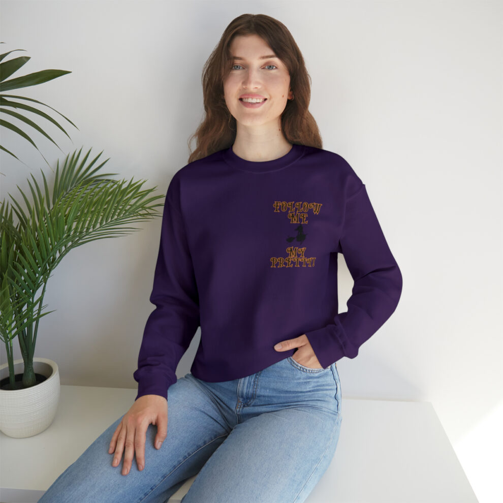 A woman sitting on the ground wearing jeans and purple sweatshirt.