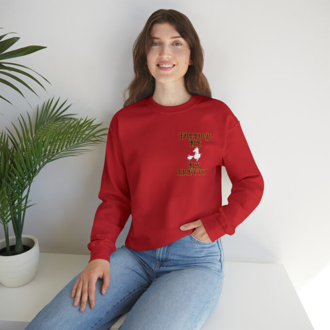 A woman sitting on the ground wearing jeans and a red sweatshirt.