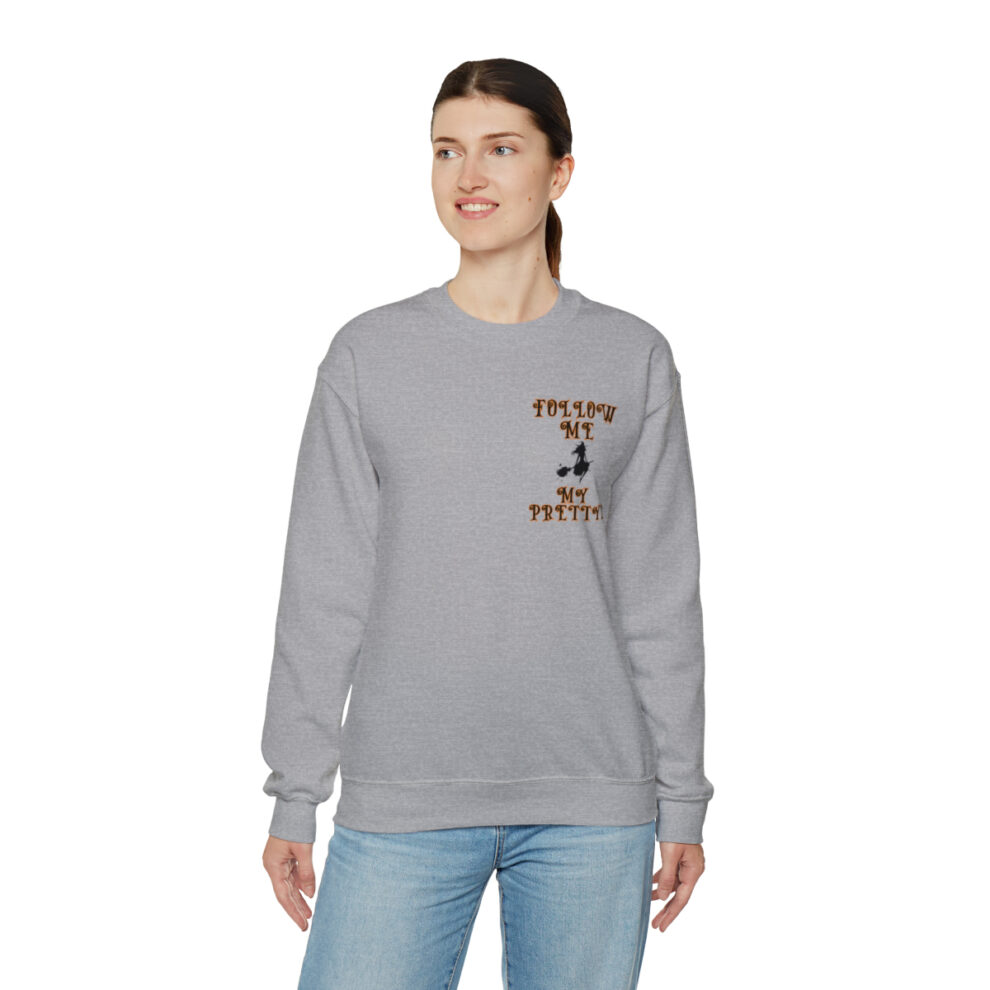 A woman wearing a gray sweatshirt with an image of a person holding something.