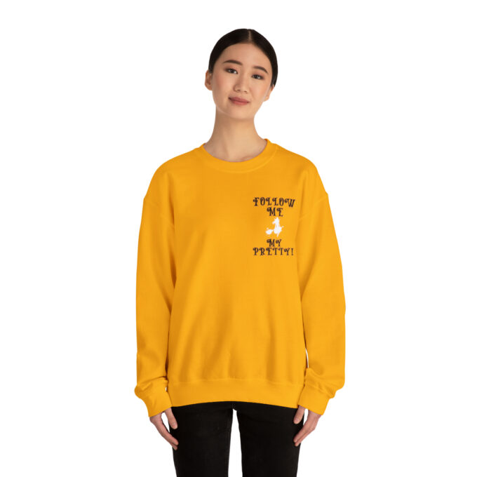 A woman wearing an orange sweatshirt with a cat on the front.