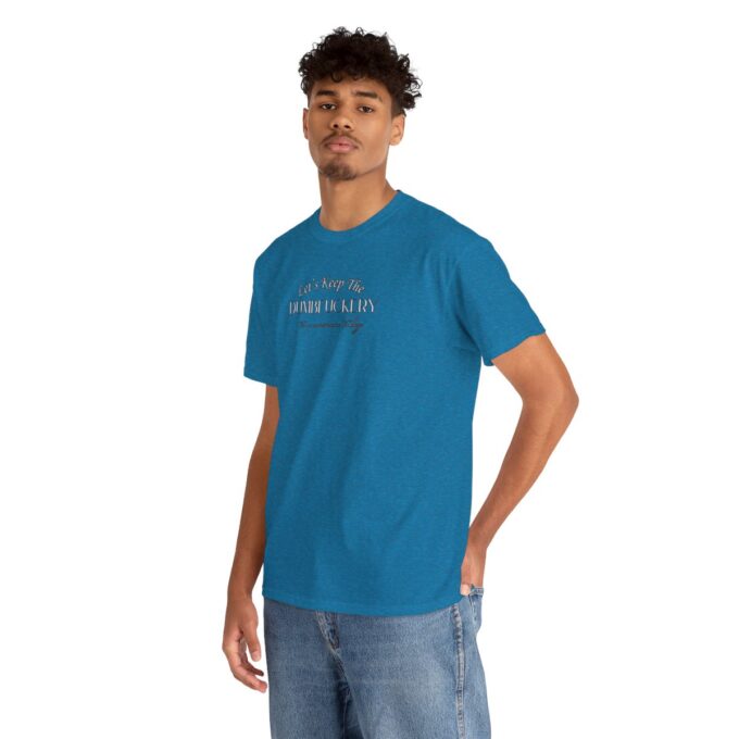 A man in blue shirt and jeans standing with his hands on hips.